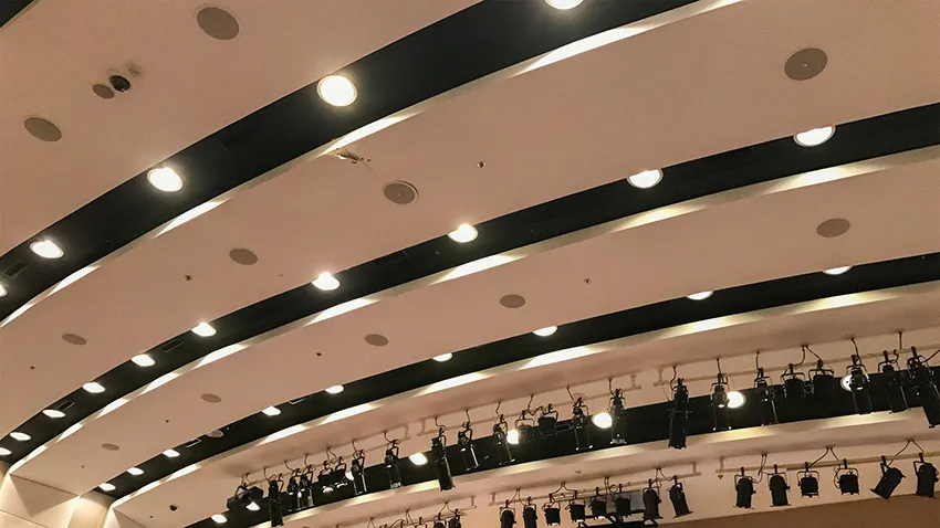 Auditorium or music hall with several architectural speakers professionally installed in ceiling.