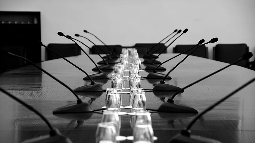 Conference room with several microphones on the table, used for audio conferencing or discussion system.